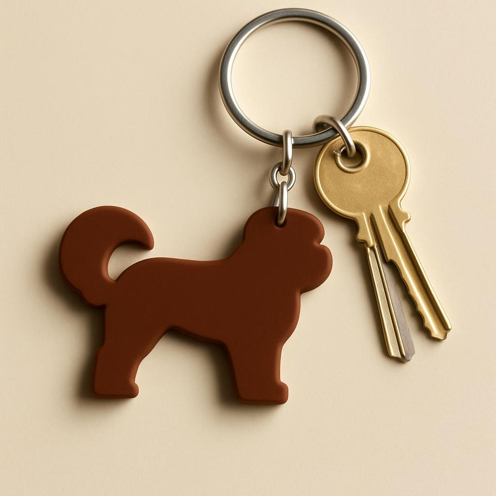 Dog-shaped keychain with a set of keys on a beige background