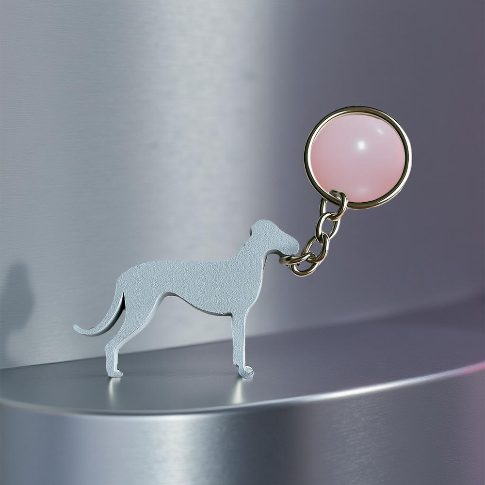 Dog-shaped keychain with a pink round tag on a metallic surface