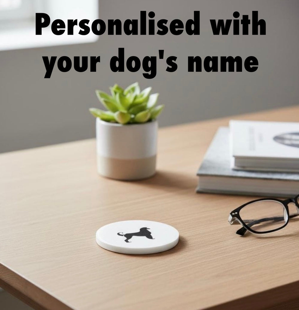 D printable Afghan Hound coaster STL file shown on a desk with plant, books and glasses, example personalised dog design