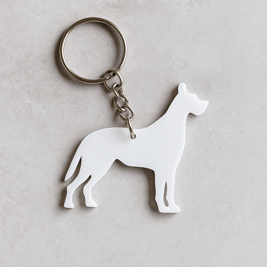 White 3D-printed Great Dane-shaped keyring  Attached to a silver keyring. shown on a neutral beige background. Minimalist custom pet accessory for dog lovers.