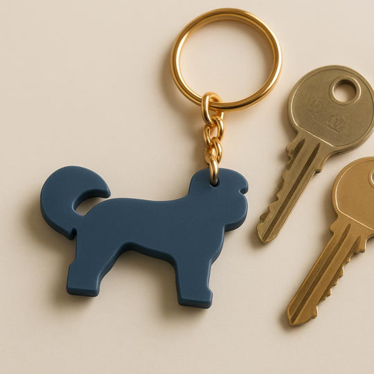 Blue dog-shaped keychain on a beige background with two gold keys.