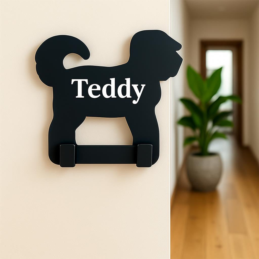 Black dog-shaped hook with 'Teddy' text on a beige wall.