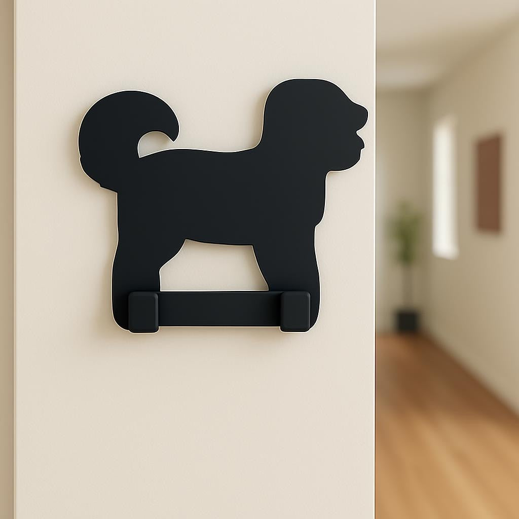 Black dog-shaped hook on a white wall with a blurred hallway in the background