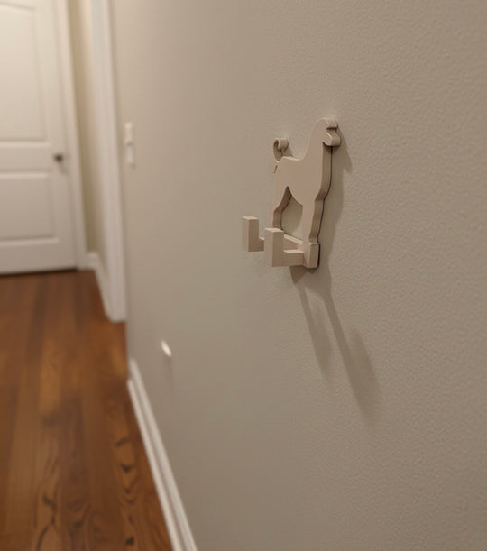 Side view of a 3D printed Afghan Hound dog wall hook mounted on a hallway wall, showing depth and hook profile in a home interior.