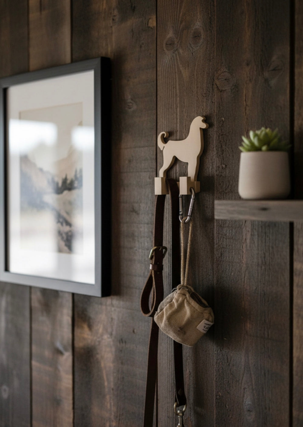 3D printed Afghan Hound dog wall hook mounted on a rustic wooden wall holding a dog leash and bag, decorative pet lead holder for home interior.