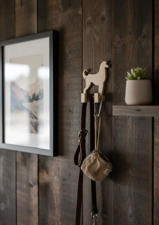 3D printed Afghan Hound dog wall hook mounted on a rustic wooden wall holding a dog leash and bag, decorative pet lead holder for home interior.
